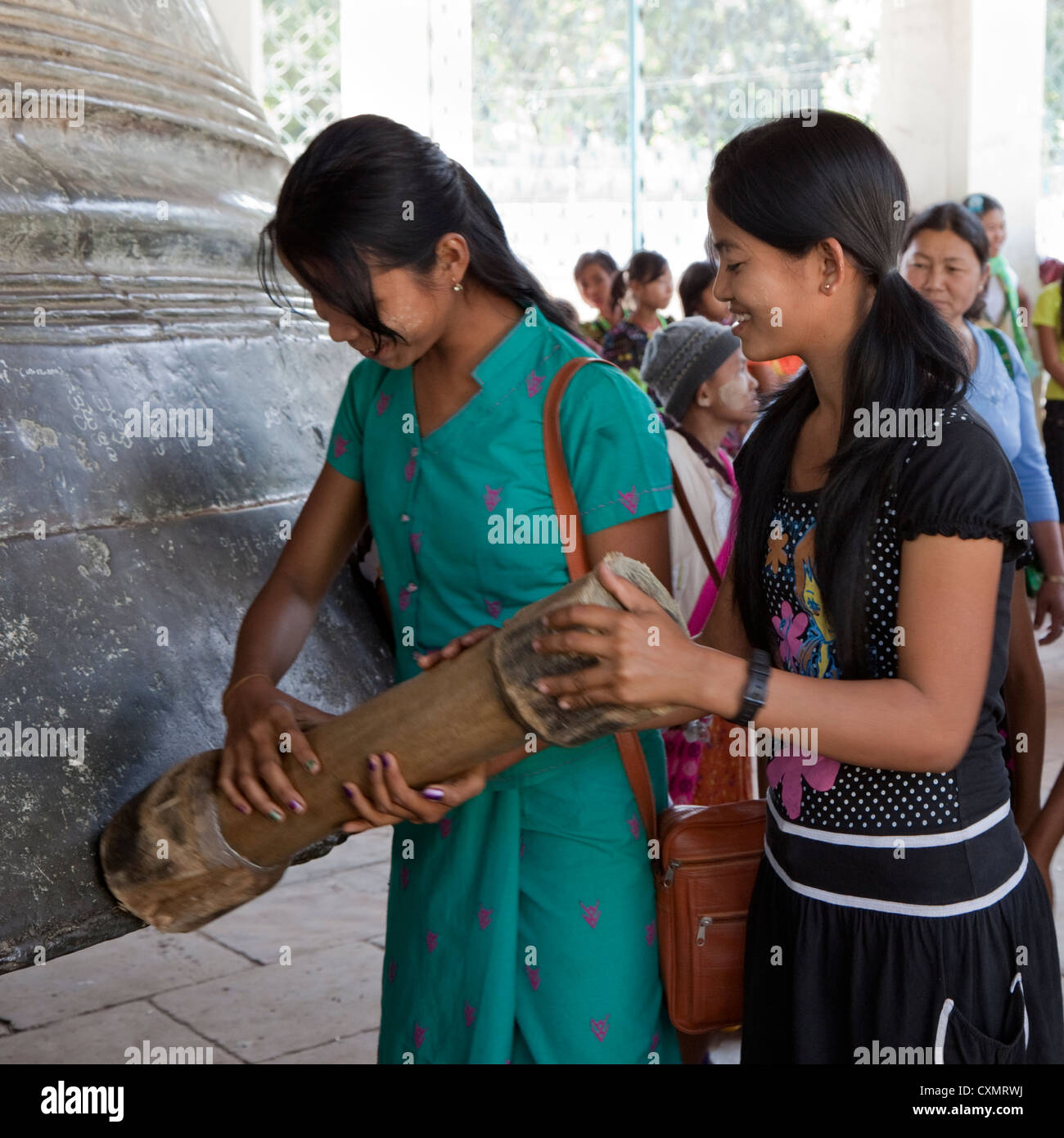 Le Myanmar, Birmanie, Mingun. Filles birmanes sonner la cloche de Mingun, fondue en 1808, la plus grande cloche accrochée dans le monde. Banque D'Images
