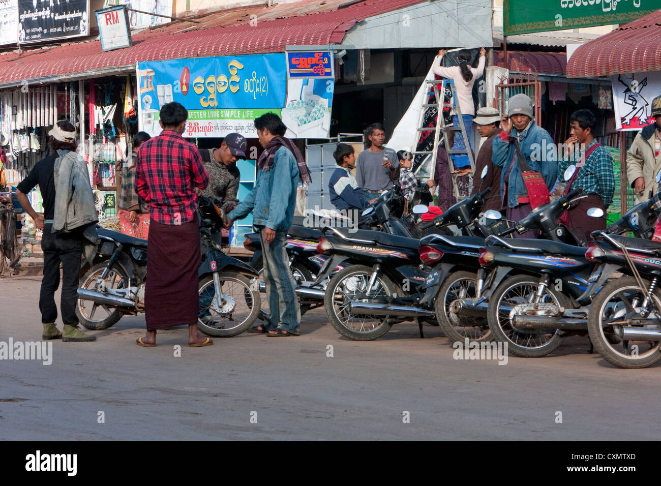 Le Myanmar, Birmanie. Kalaw Scène de rue. Les hommes birmans en discutant de leurs motos. Banque D'Images