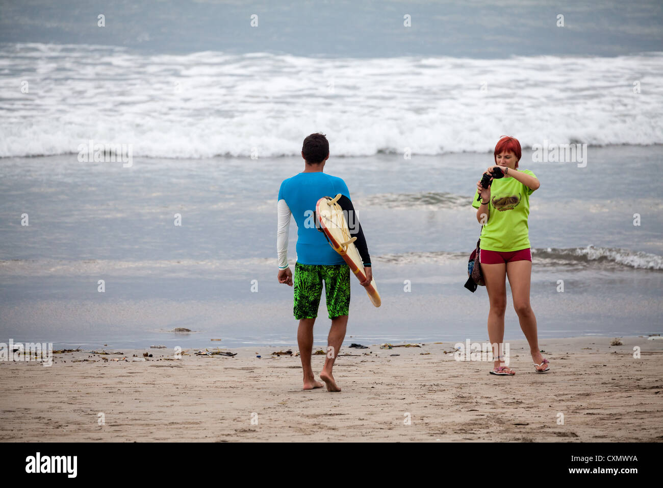 Surfer sur la plage de Kuta à Bali Banque D'Images