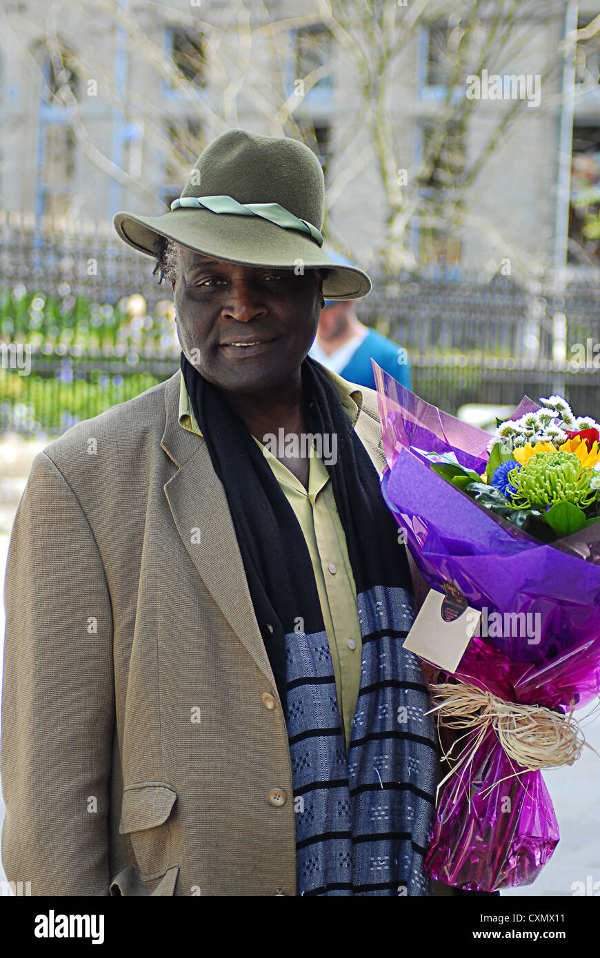 Homme noir à meilleurs vêtements portant un bouquet de fleurs Banque D'Images