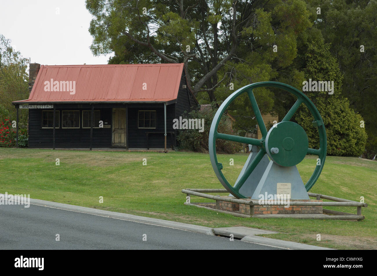 Meubles anciens Miner's Cottage et volant moteur sur l'affichage à Beaconsfield, Tasmanie. Banque D'Images