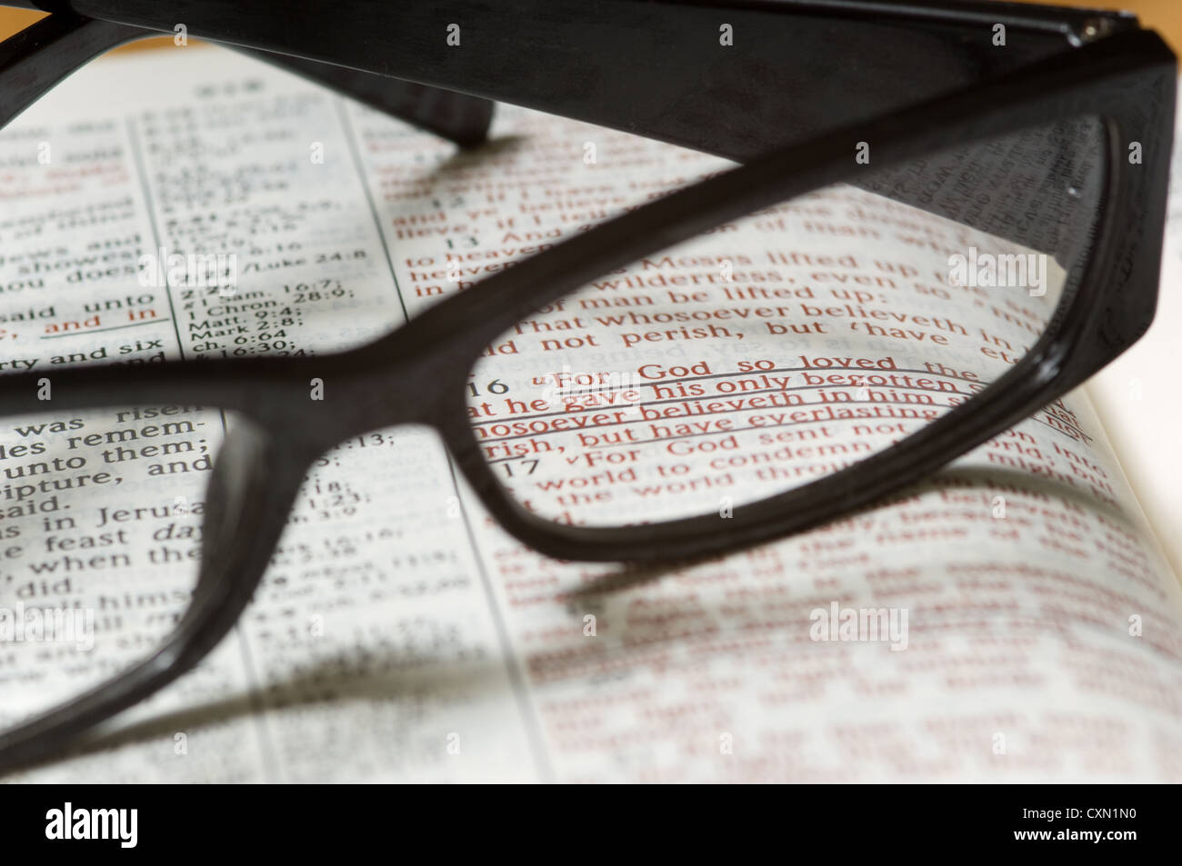 Une paire de lunettes de lecture sur le dessus d'une une Bible ouverte à Jean 3, l'étude religieuse Banque D'Images
