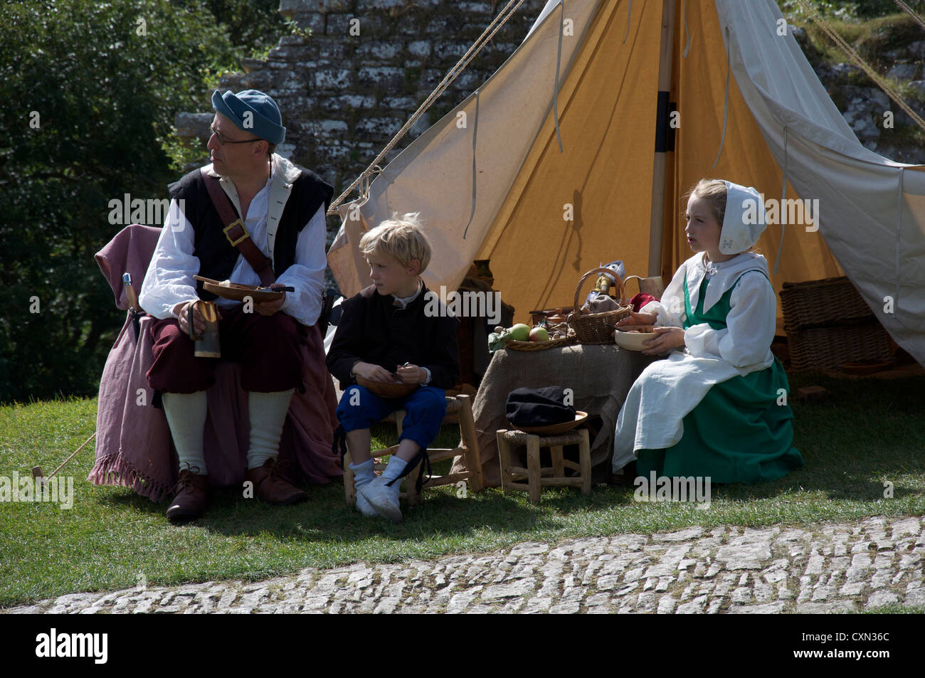 Un père avec ses deux enfants, membres d'un groupe de reconstitution de la guerre civile anglaise. Dans une reconstitution de la vie Anglaise du 17ème siècle. Dorset, Angleterre, Royaume-Uni. Banque D'Images