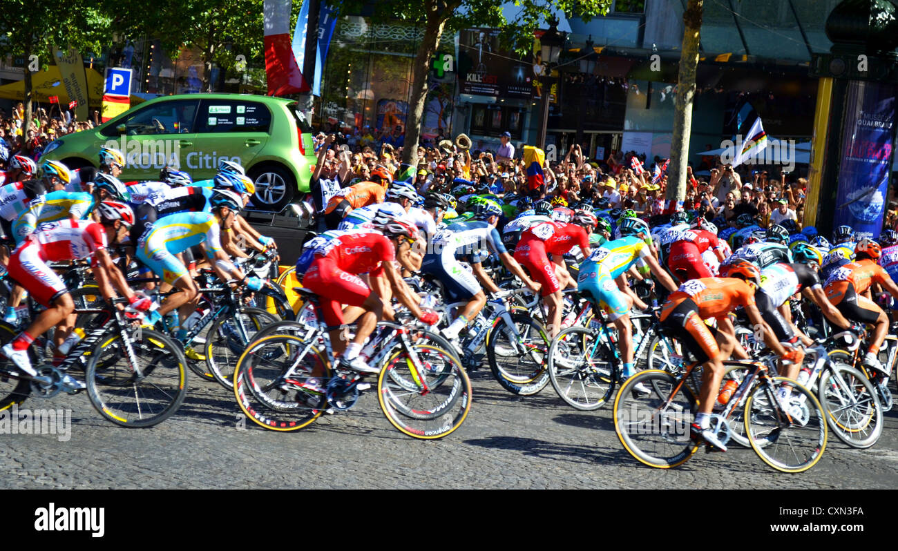 Le Tour de France peleton arrondit le plier en haut de l'avenue des Champs-Élysées. Banque D'Images