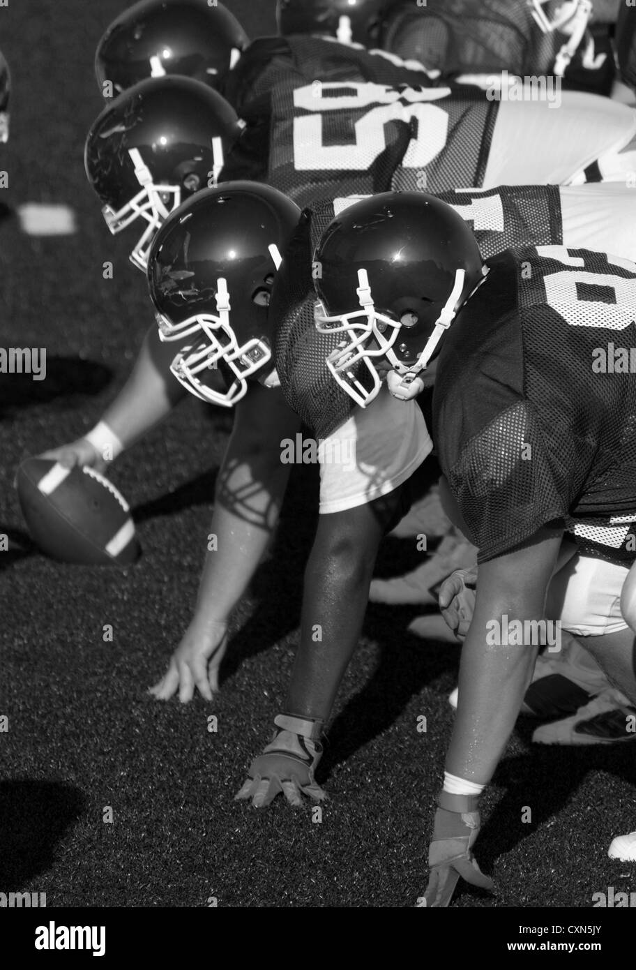 Football américain joué par les jeunes hommes, la préparation de la ligne offensive pour le jonc ou pour la lecture pour commencer à Banque D'Images