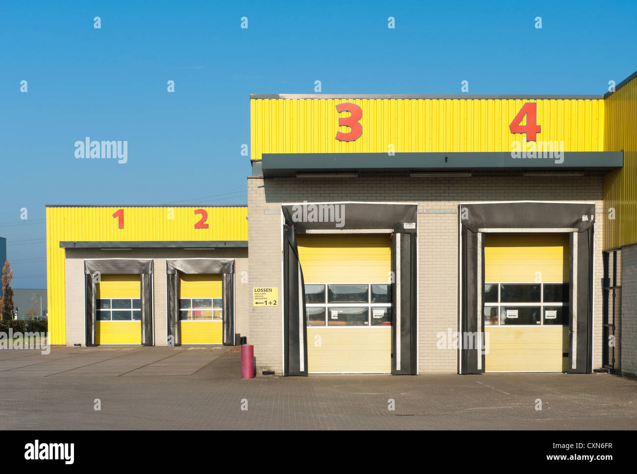 Entrepôt industriel jaunes numérotés avec quais de chargement Banque D'Images