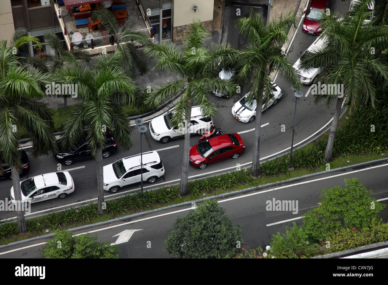 C'est une photo Vue de dessus d'un embouteillage dans les rues de Manille, aux Philippines, en Asie. Les voitures sont coincés près de la paume Banque D'Images