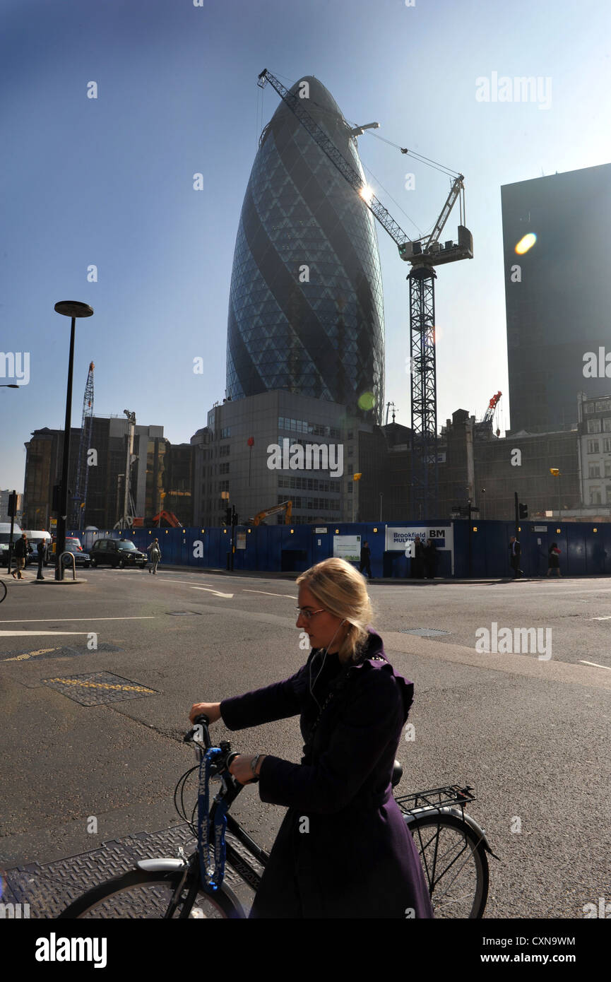 Cycliste, Londres avec le Gherkin building et des nouveaux développements dans l'arrière-plan. Banque D'Images