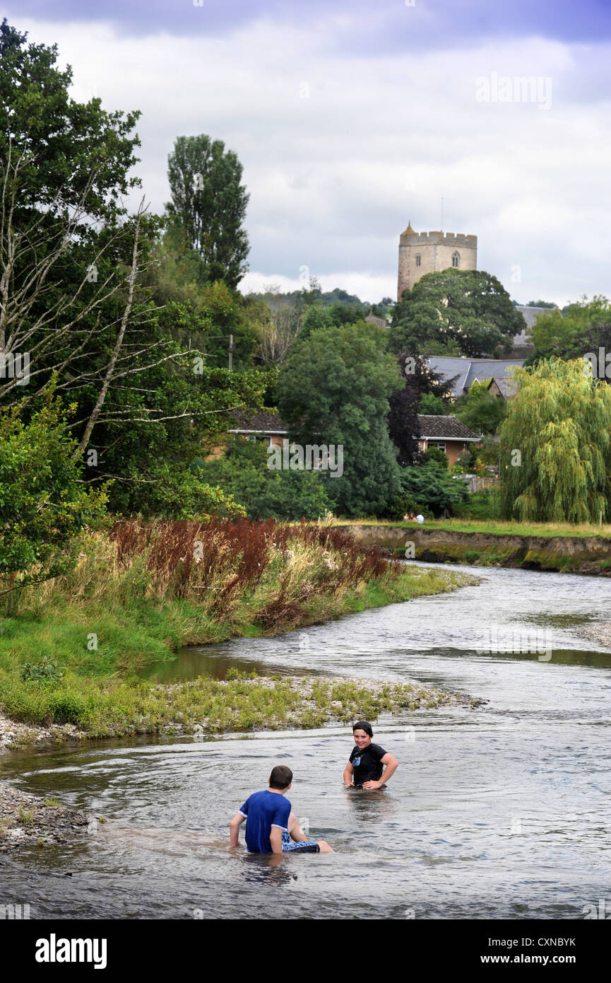 Le village de Leintwardine avec enfants se baignant dans la rivière teme, Herefordshire UK Banque D'Images