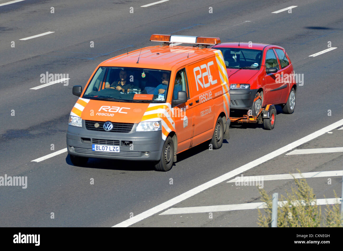 Vue latérale et avant du logo de la marque sur le RAC VW Volkswagen panne  de la camionnette commerciale, remorquage du conducteur et du passager,  rouge, panne Voiture sur l'autoroute britannique Angleterre