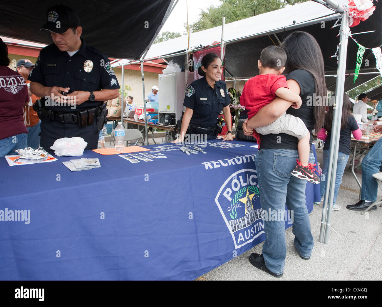 Portrait policier parle de femme exerçant son jeune fils à Austin Police Department stand recrutement festival en plein air Banque D'Images