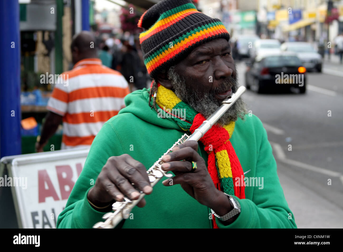 Joueur de flûte à l'flutewise à Londres, dans des couleurs du drapeau jamaïcain rastafari port anneau de doigt, trois petits oiseaux. Banque D'Images
