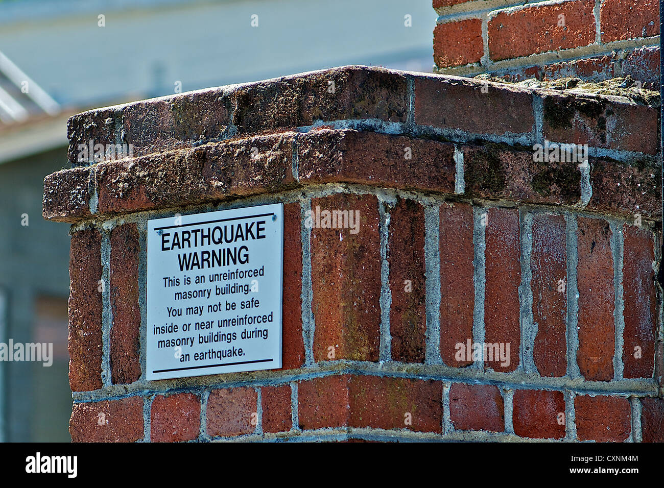 Tremblement de panneau d'avertissement sur l'édifice de brique Banque D'Images