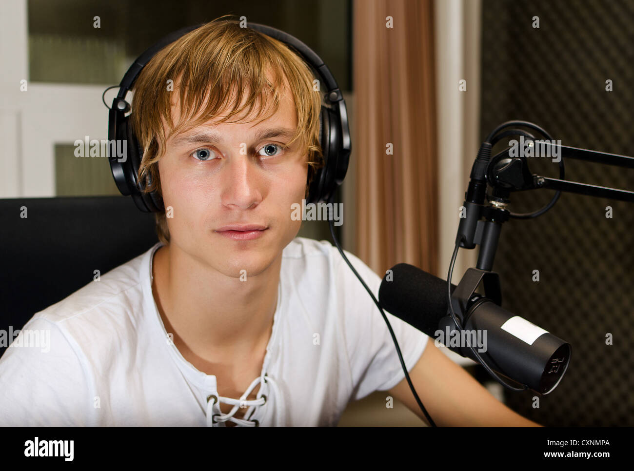 Portrait of male dj travaillant devant un micro à la radio Banque D'Images