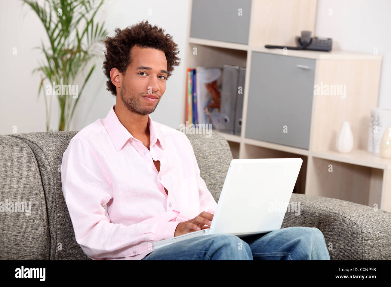 Couple sitting on sofa with computer Banque D'Images