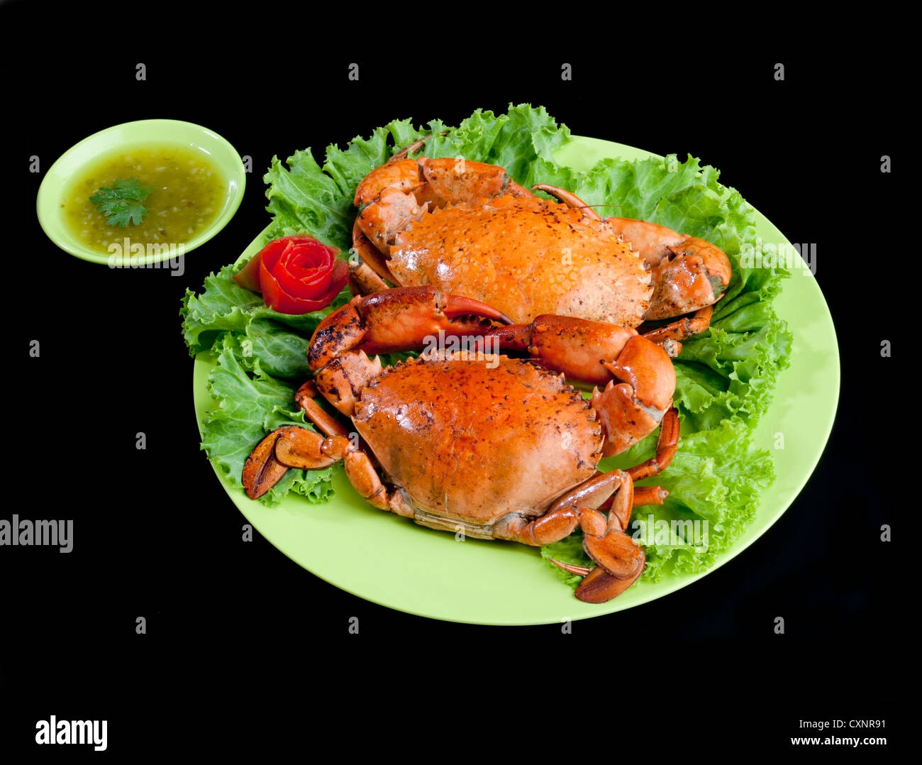 Les crabes à la vapeur d'un grand écran plat de fruits de mer savoureux sur isolé sur fond noir Banque D'Images