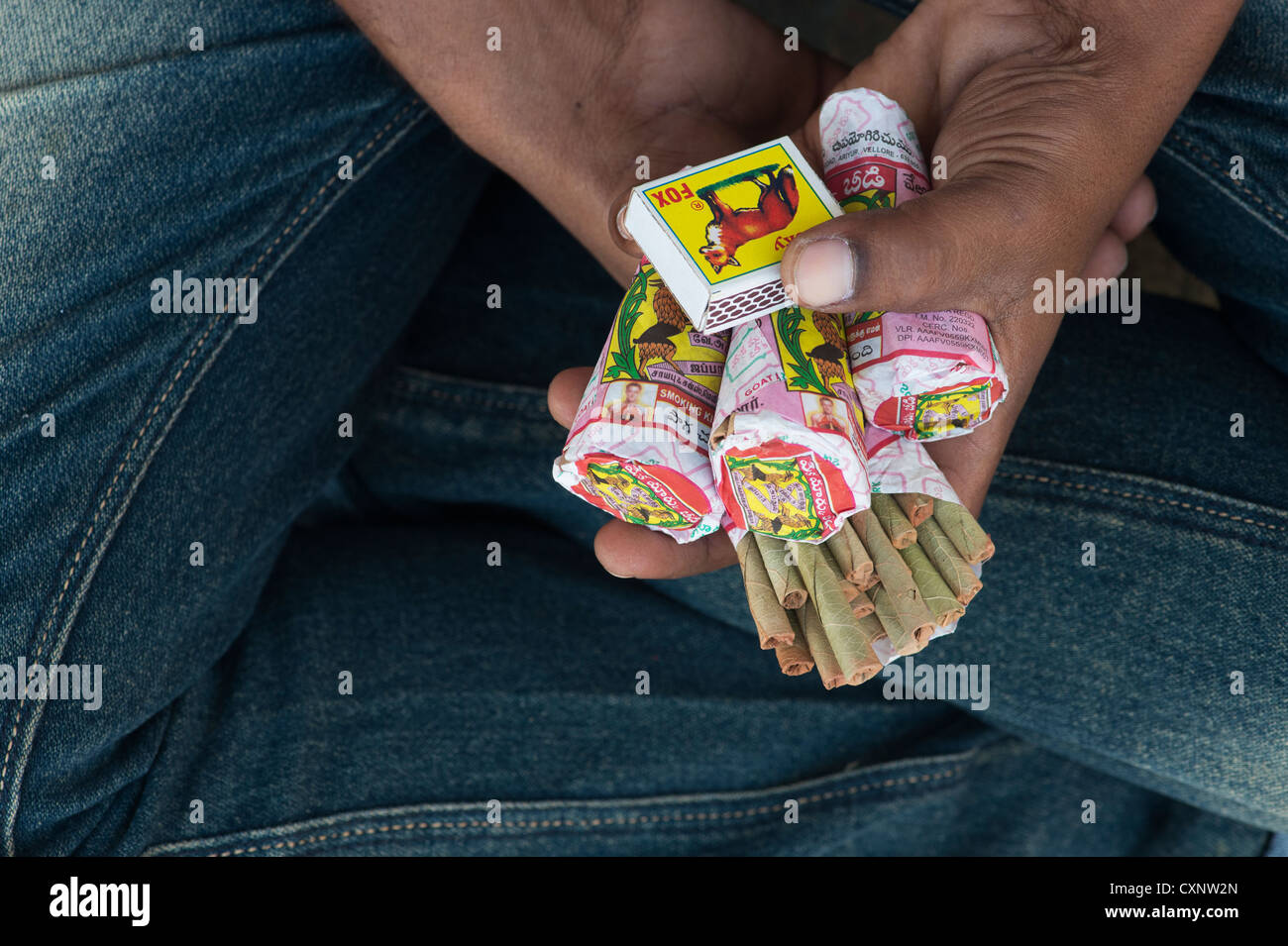Indian man holding packets de beedies Indiennes et une boîte d'allumettes dans sa main Banque D'Images