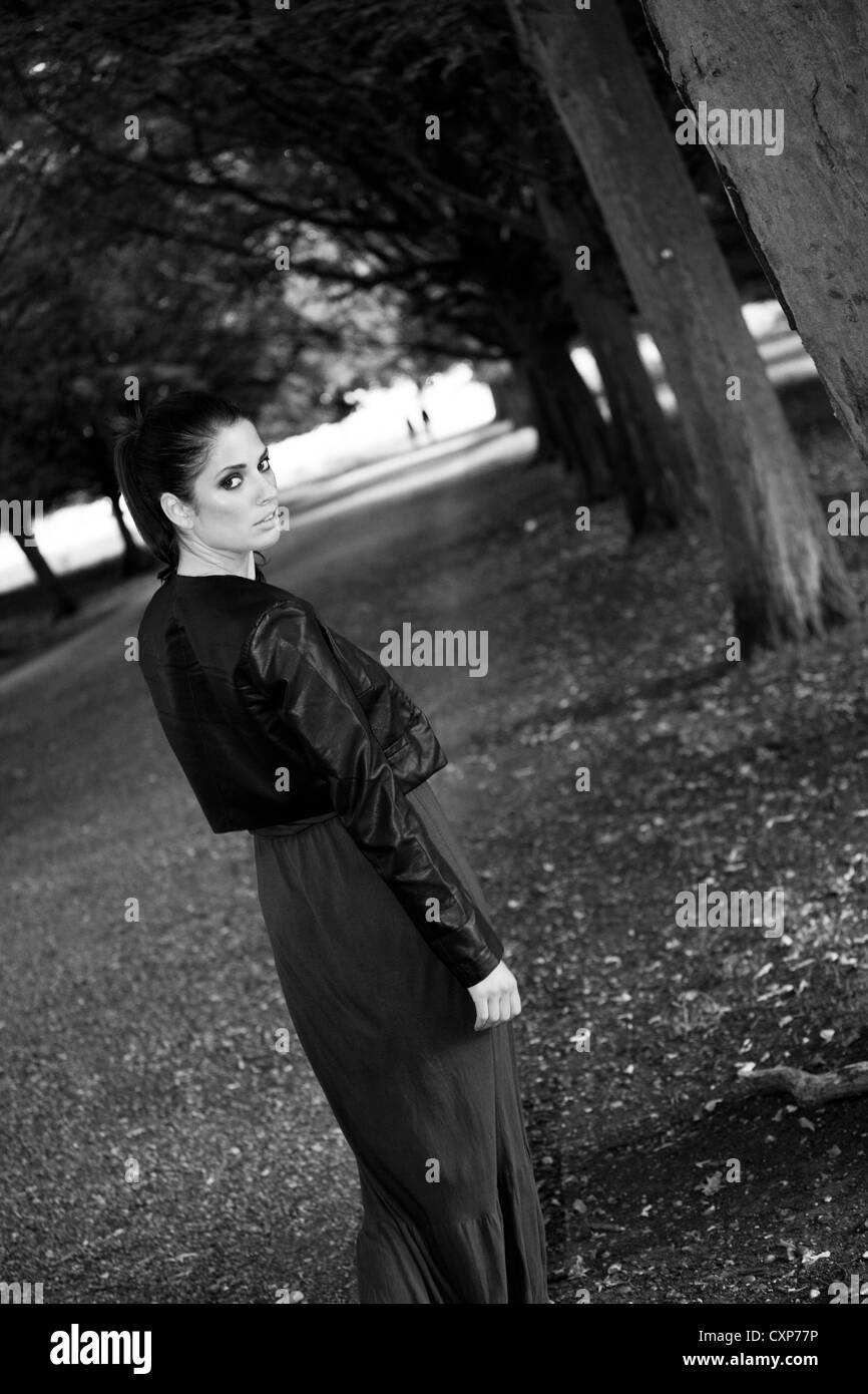 Femme à la Par-dessus son épaule en arrière le long d'un chemin dans un parc Banque D'Images