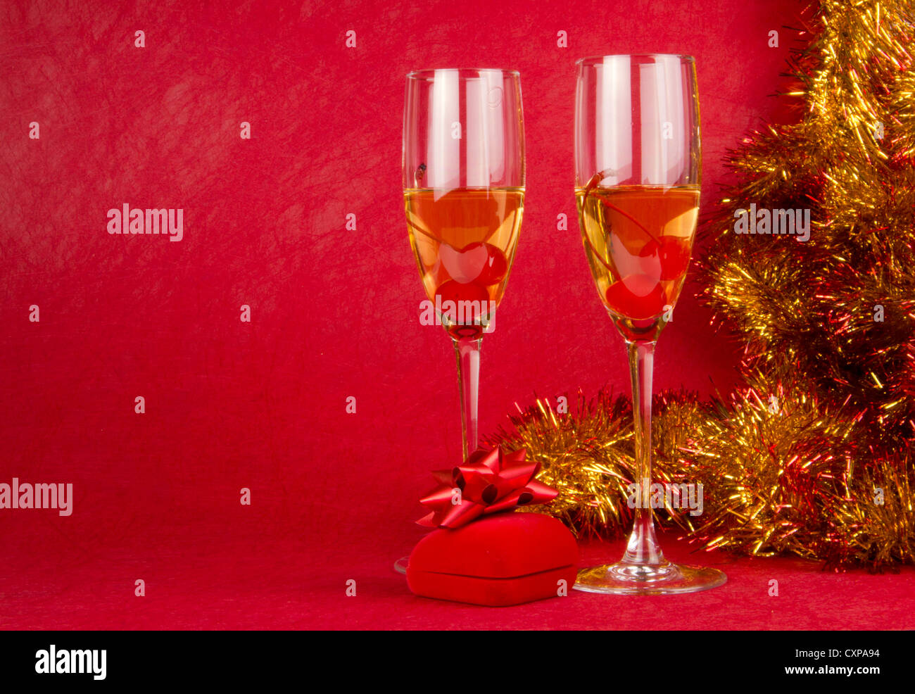 Cadeau de Noël boîte de bijoutier et verres de champagne sur fond rouge Banque D'Images