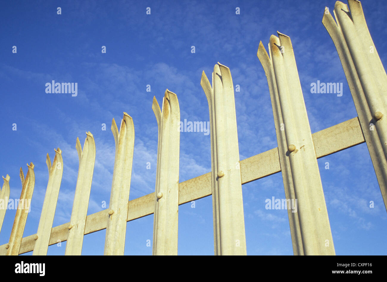 Détail de la clôture de sécurité en aluminium avec des griffes, en haut de chaque barre verticale et bleu ciel derrière Banque D'Images