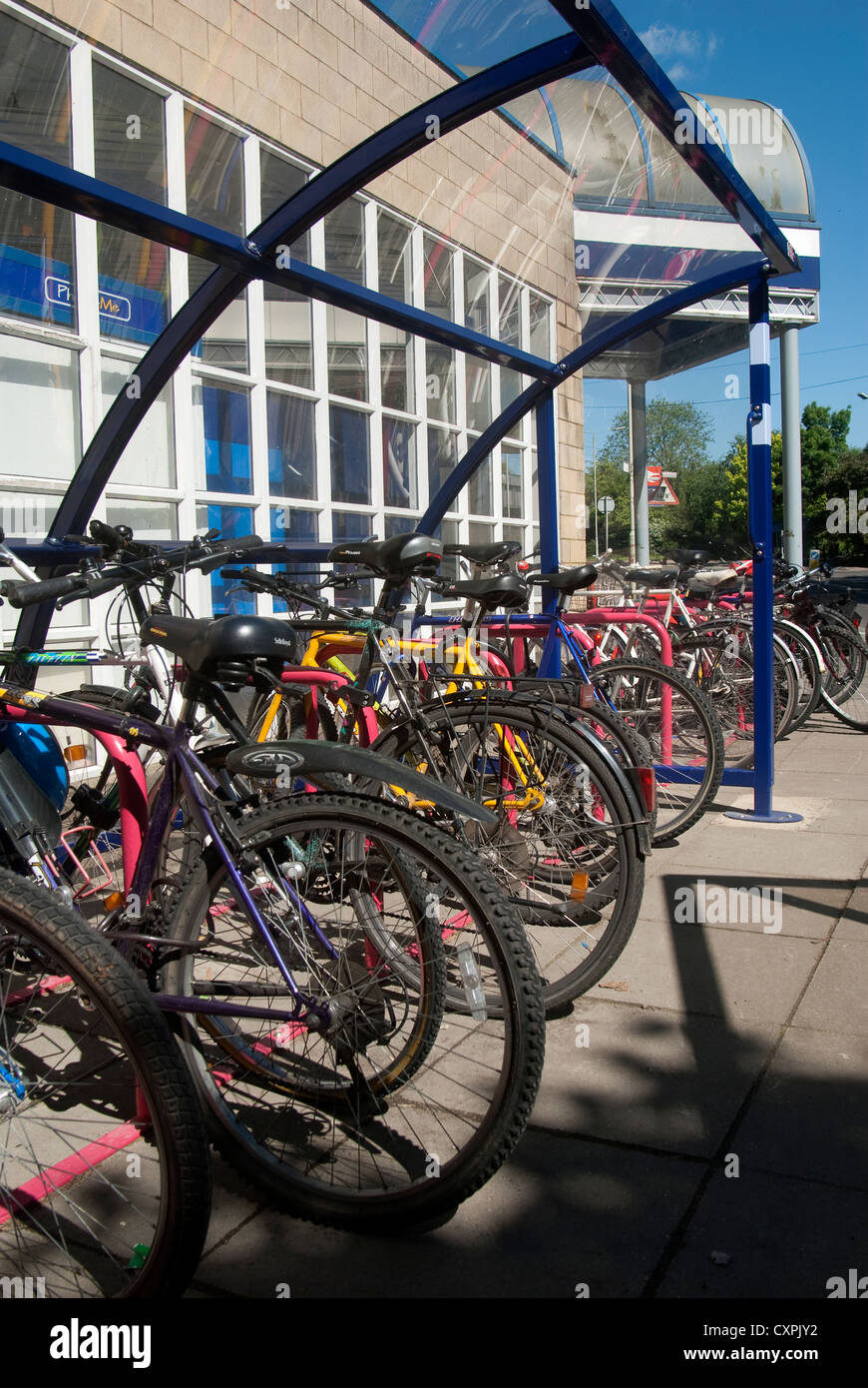 Les vélos garés devant une gare ferroviaire en Angleterre. Banque D'Images