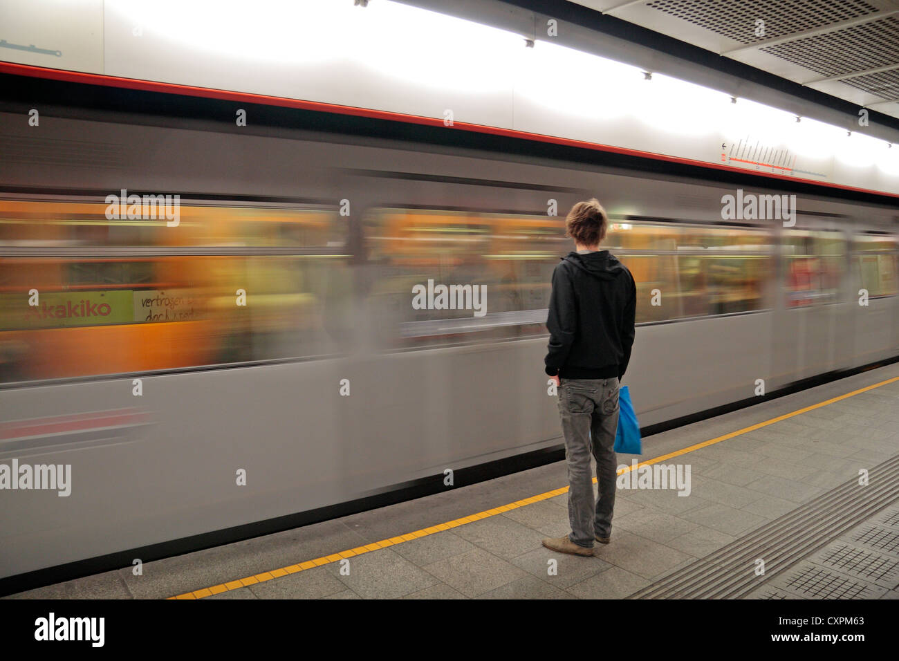 Un homme sur le système de métro autrichien, Vienne, debout sur une plate-forme comme un train arrive. Banque D'Images