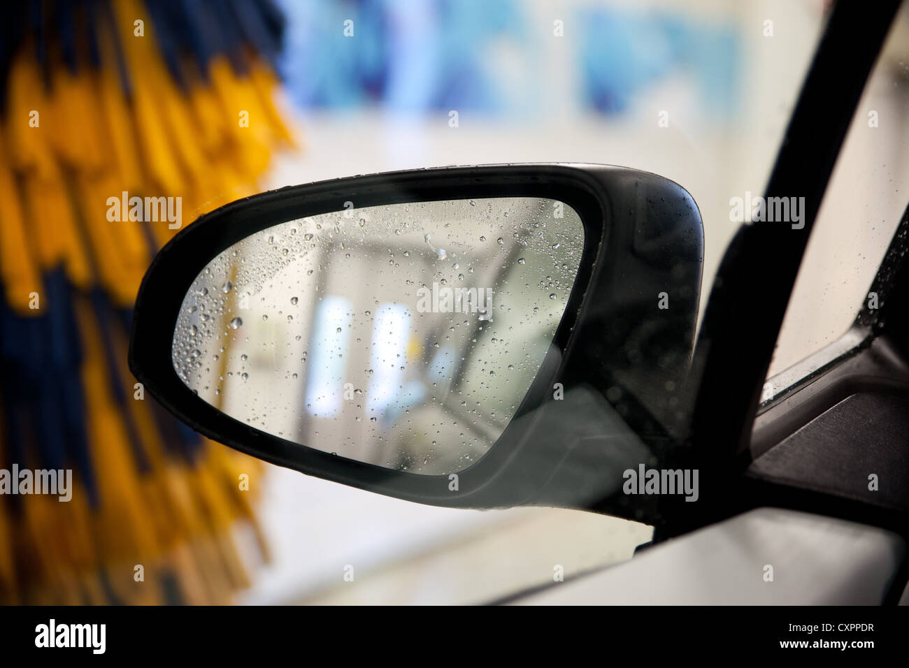 Miroir de voiture, humide. Équipement de lavage de voiture à l'arrière-plan Banque D'Images