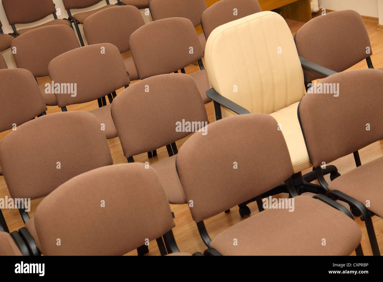Président Manager se distingue parmi les rangées de chaises de bureau ordinaires Banque D'Images