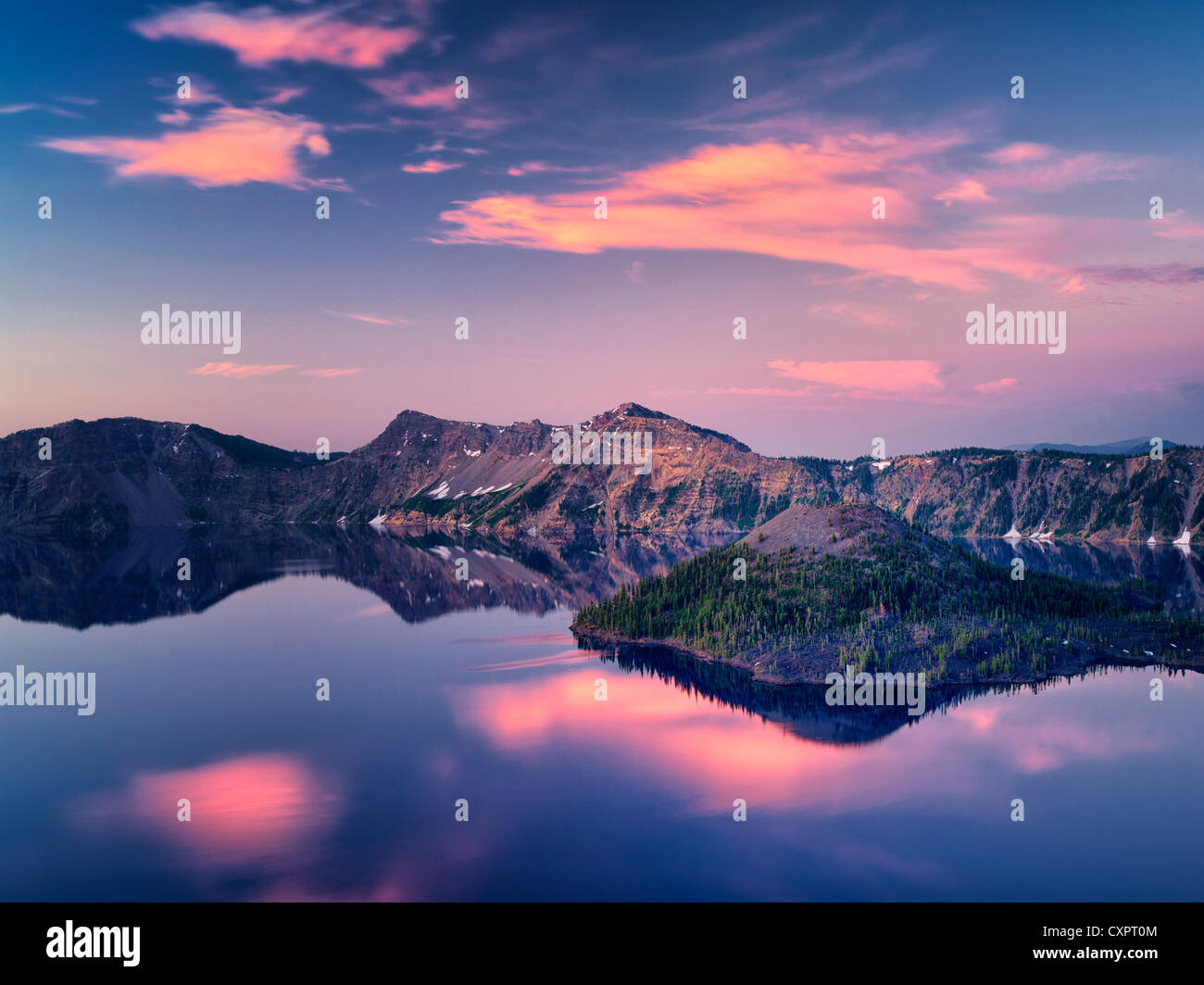 Le lac du cratère de l'île de l'assistant au lever du soleil . Crater Lake National Park, Oregon, le lever du soleil les nuages se reflétant dans les eaux calmes Banque D'Images