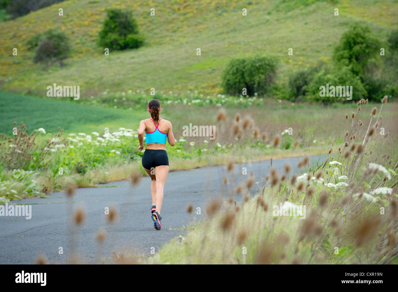 Young woman running in rural setting Banque D'Images