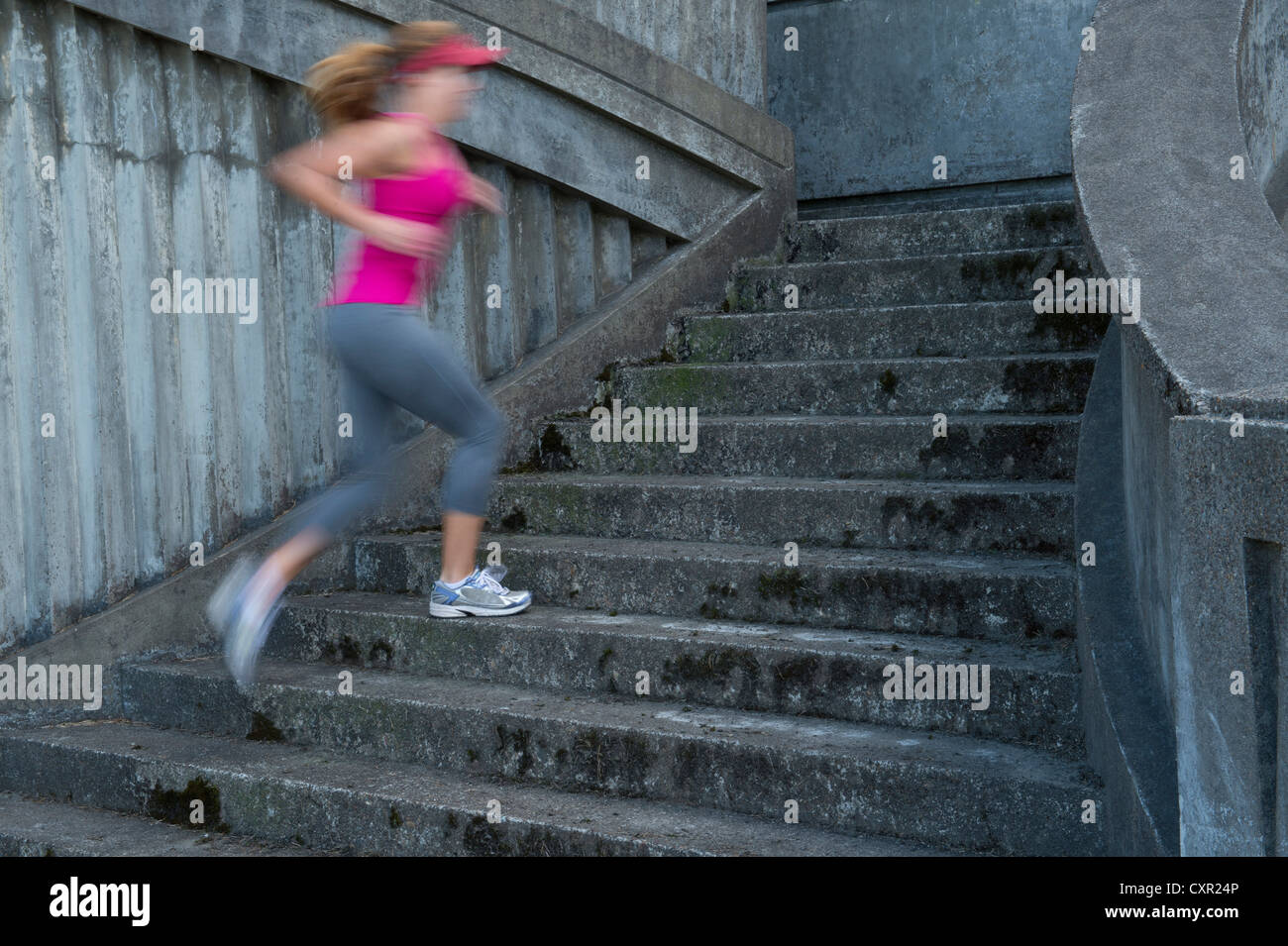 Jeune femme en marche vers le haut des escaliers, le motion blur Banque D'Images