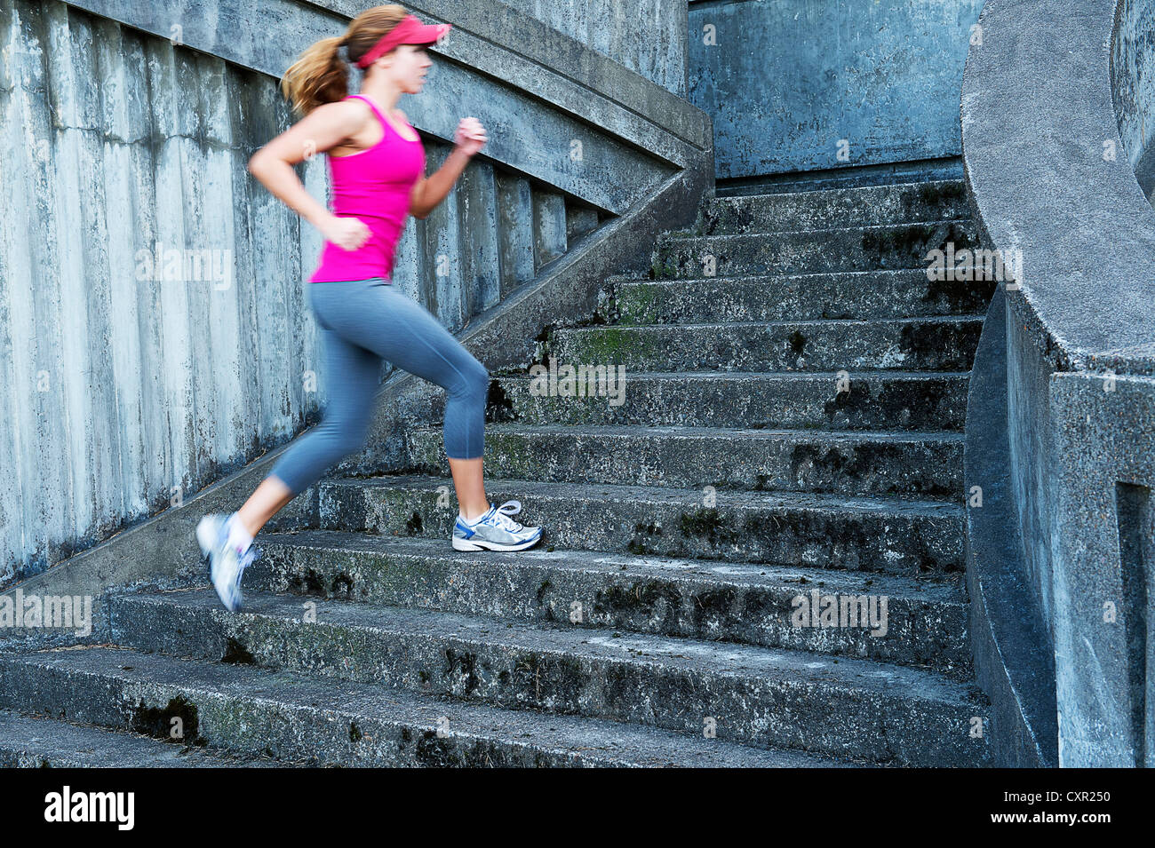 Young woman running up stairs Banque D'Images
