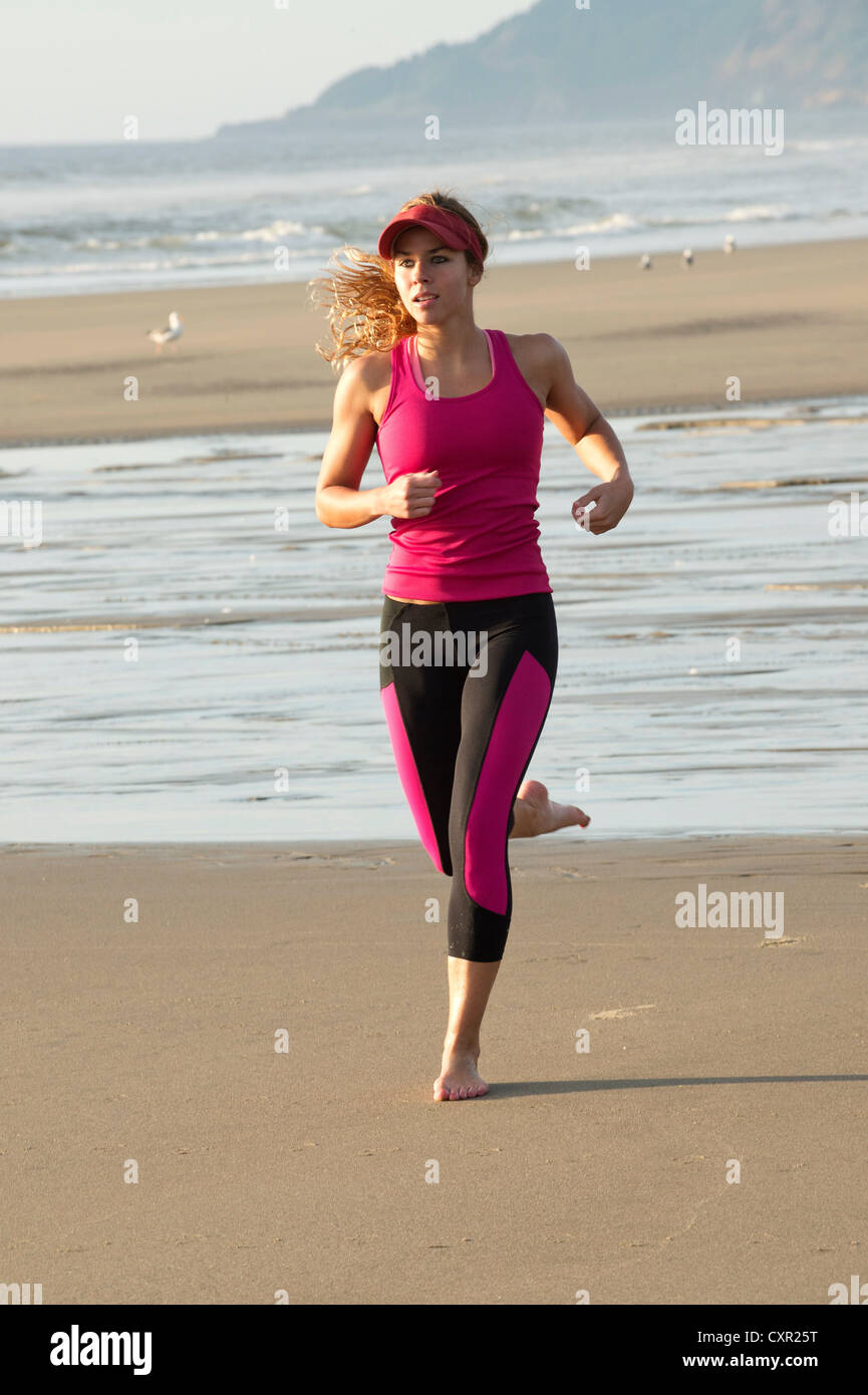 Young woman running on beach Banque D'Images