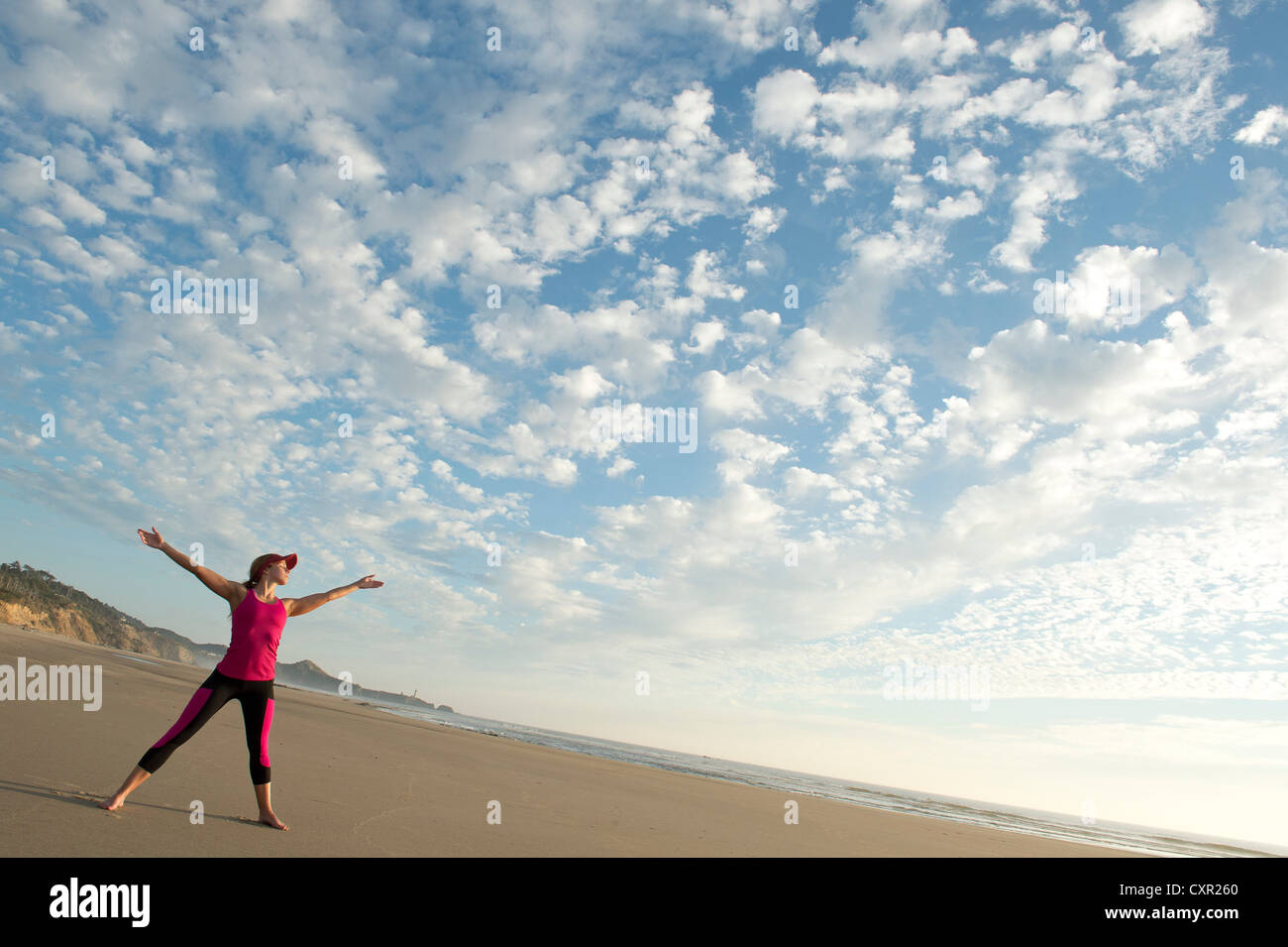 Jeune femme sur la plage avec les bras tendus Banque D'Images