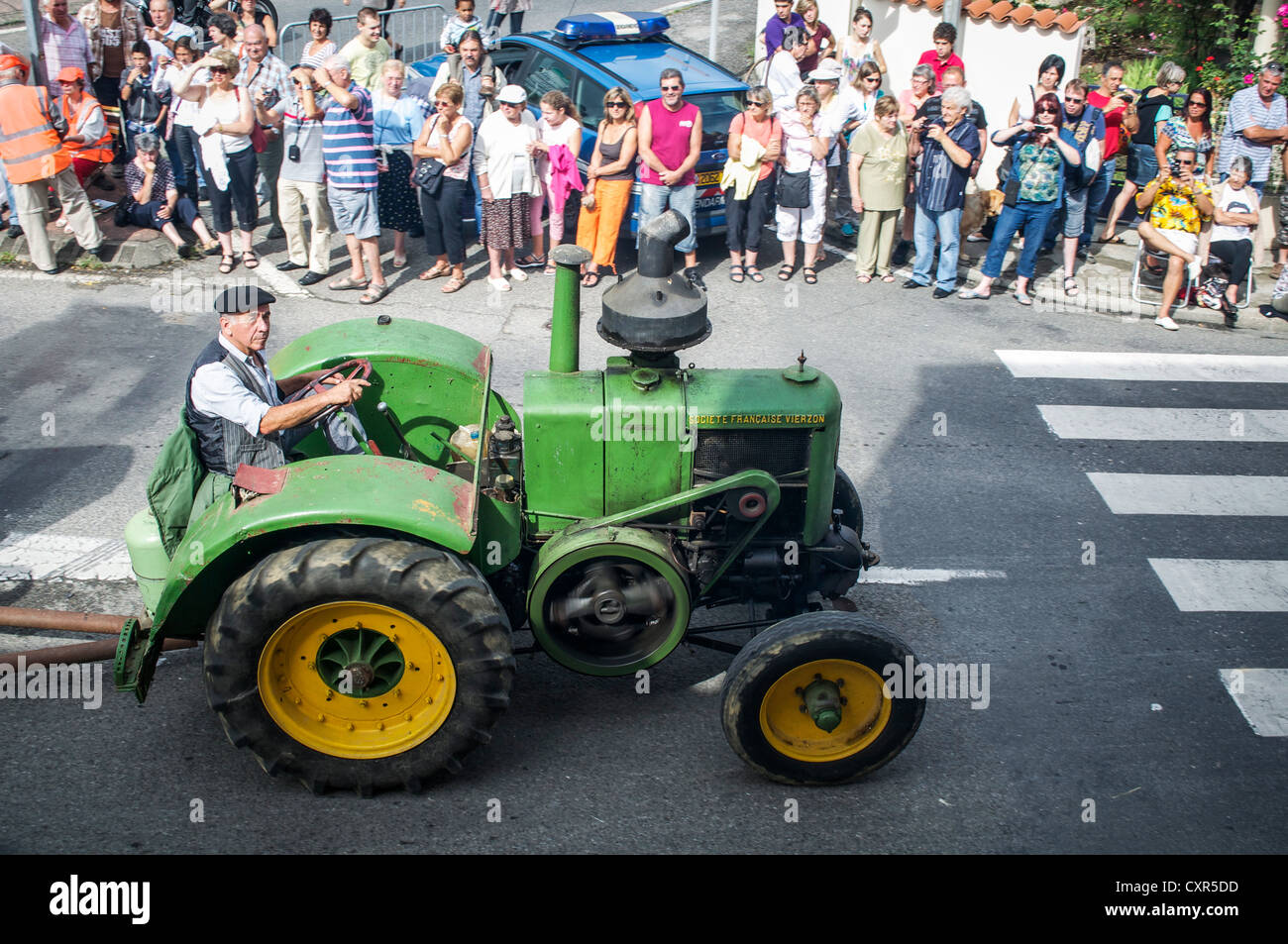 Homme portant un béret vert vintage conduite tracteur à Autrefois Le défilé Couserons à St. Girons, Midi-Pyrenees, France. Banque D'Images