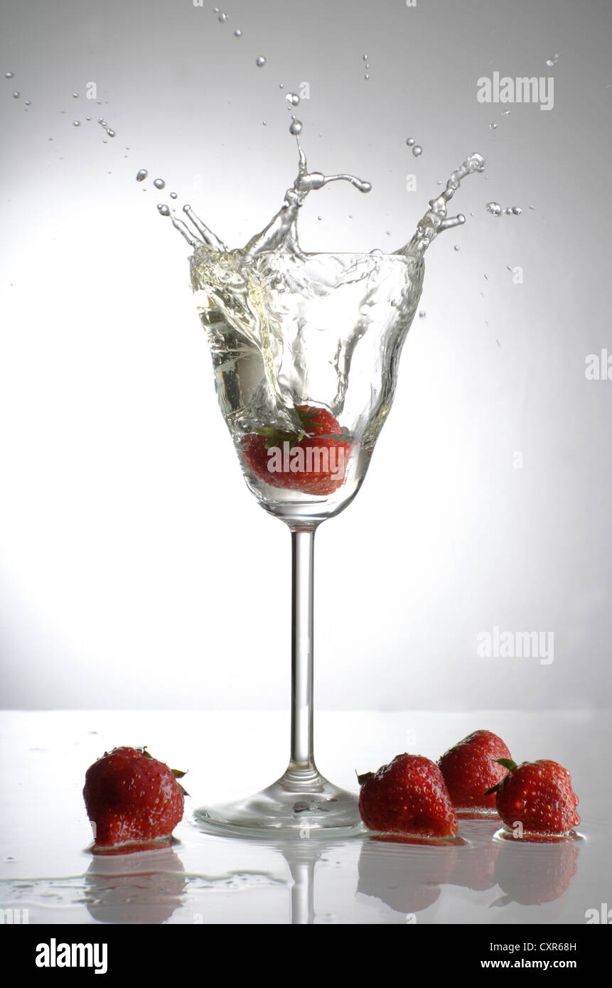 Strawberry tombé dans un verre de champagne Banque D'Images