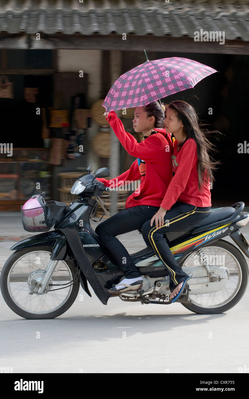 Deux jeunes femmes ride par sur une moto à Luang Prabang, Laos Photo Stock  - Alamy