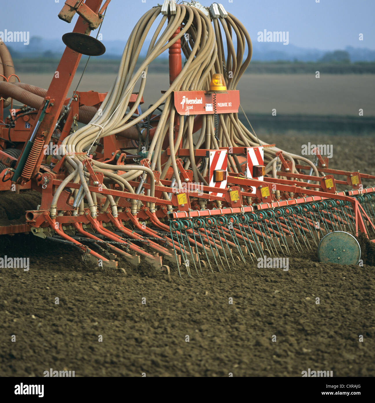 La récolte céréalière de la plantation avec un Kvernland marteau pneumatique monté sur tracteur John Deere, Devon Banque D'Images