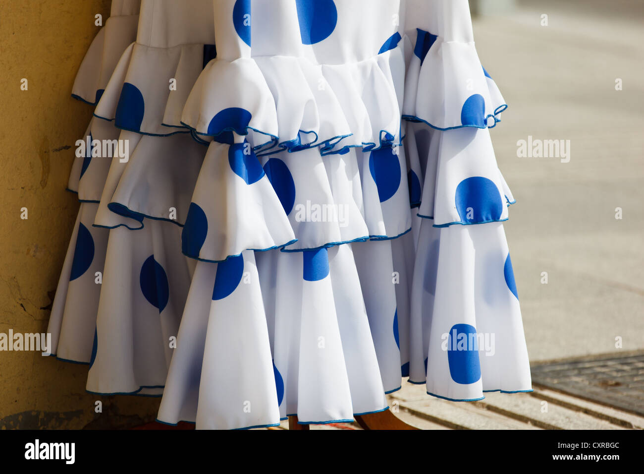 Volants et ourlet de robe de danseuse flamenco blanche avec pokadots bleus. Banque D'Images