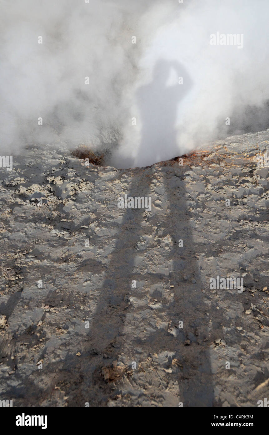Photographe jette une ombre sur un nuage de vapeur d'un geyser, champ géothermique "sol de mañana" dans la matinée, près de Uyuni Banque D'Images