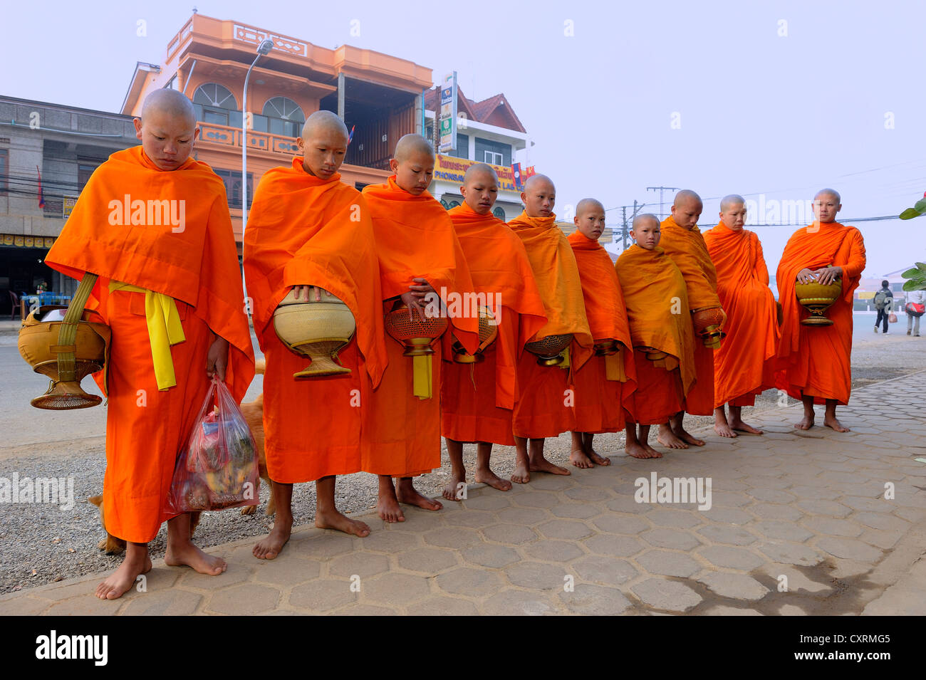 Mendiants bouddhistes tôt le matin, en attente de l'aumône dans la rue principale de Phonsavan, Laos, Asie du sud-est asiatique Banque D'Images