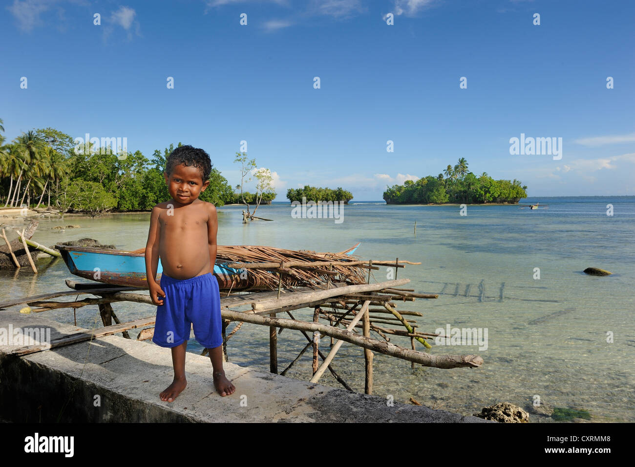 Garçon papoue, debout devant un lagon sur l'île de Biak, au large de l'île de Papouasie-Nouvelle-Guinée, en Indonésie, en Asie du Sud-Est, l'Asie Banque D'Images