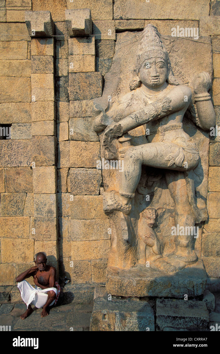Homme assis sous un démon statue, temple de Brihadisvara, site du patrimoine mondial de l'UNESCO, Gangaikonda Cholapuram, Tamil Nadu Banque D'Images