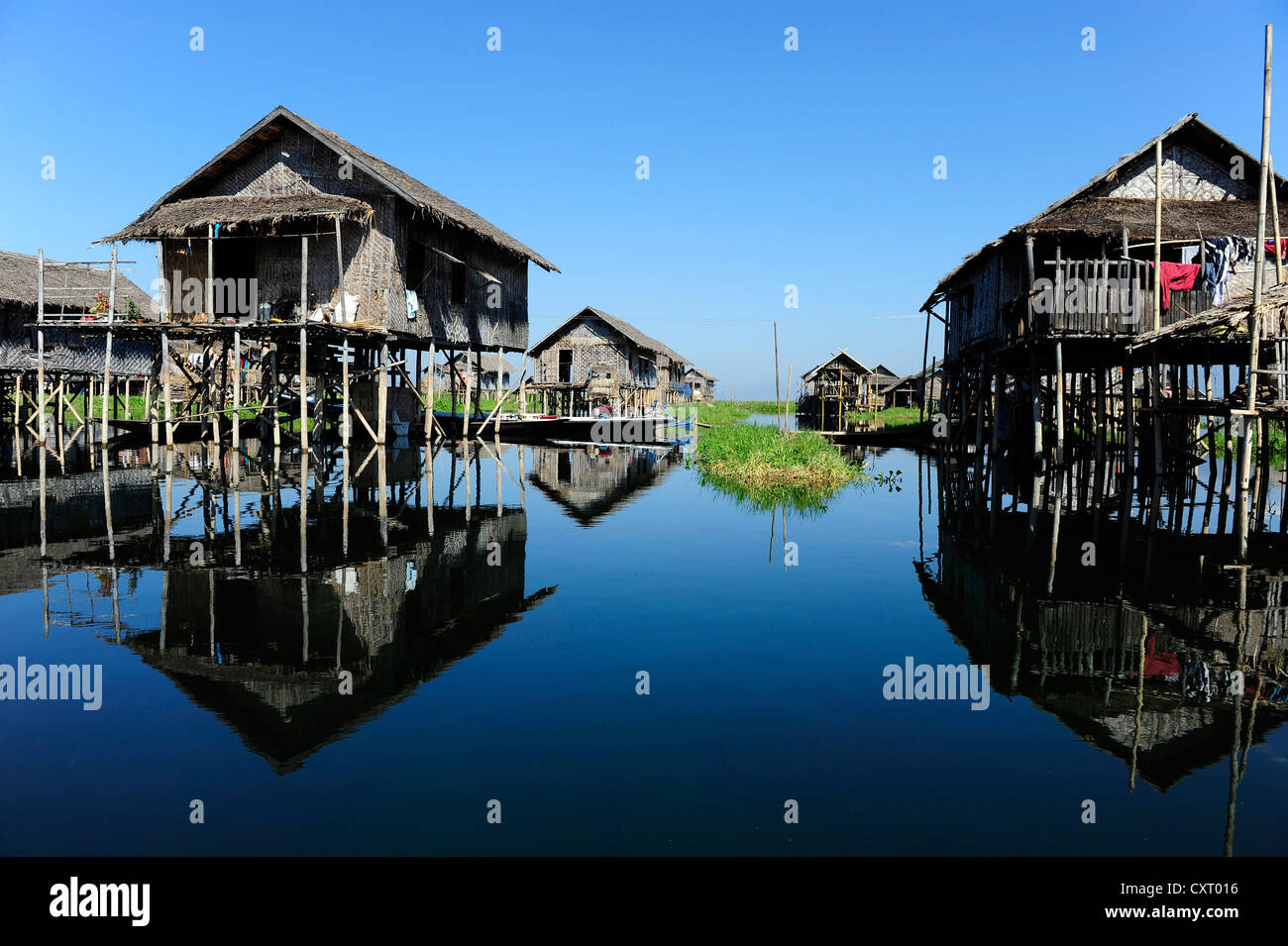 Des maisons sur pilotis avec des réflexions sur le lac Inle, en Birmanie aussi connu sous le nom de Myanmar, en Asie du Sud-Est, l'Asie Banque D'Images