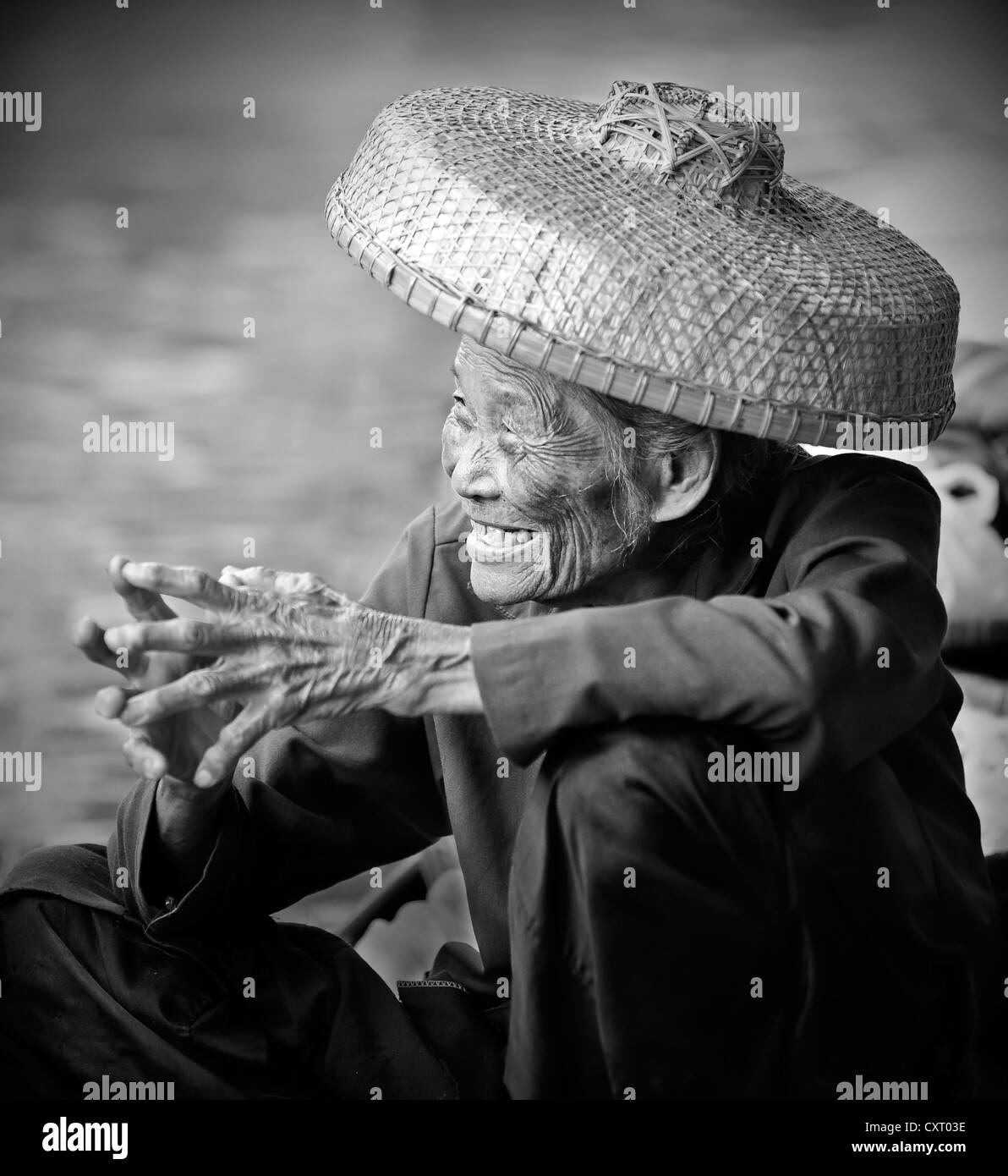Smiling vieille femme portant un chapeau de paille au marché flottant de Damnoen Saduak,, la Thaïlande, l'Asie du Sud-Est, l'Asie Banque D'Images