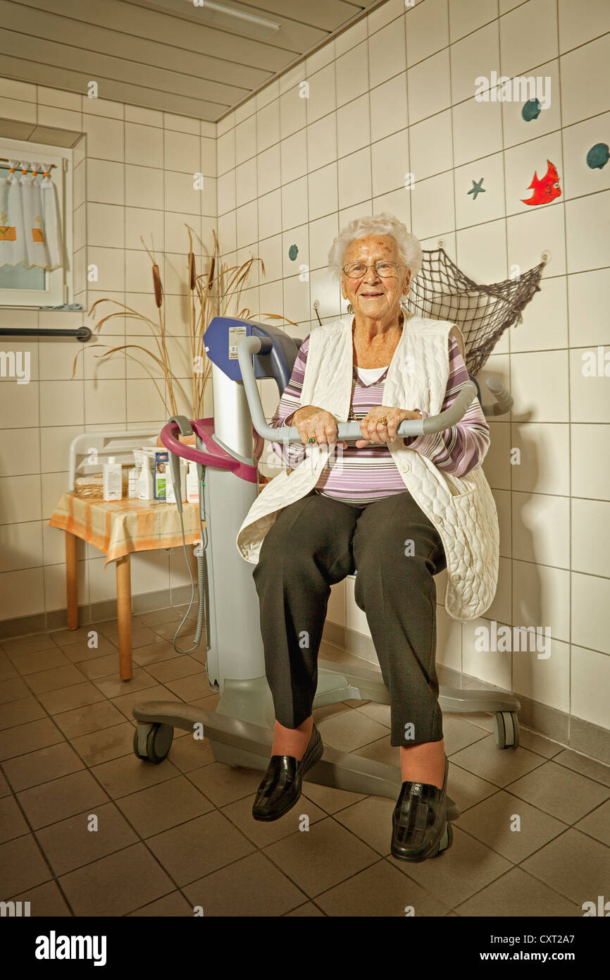 Femme âgée assise dans une baignoire ascenseur, aide médicale Banque D'Images