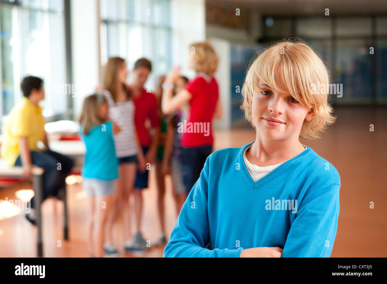 Boy, portrait, debout devant un groupe d'écoliers dans une école Banque D'Images