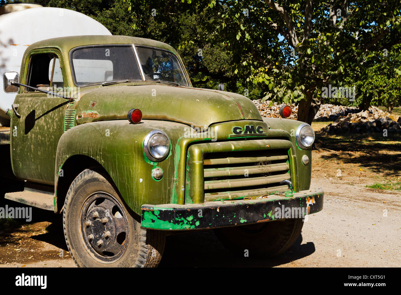 Un vieux camion-citerne GMC délabré parqués dans un verger Banque D'Images