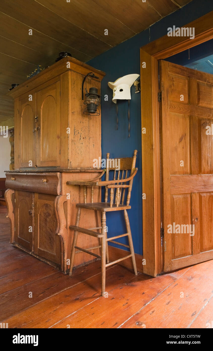 Armoire en pin antique et une chaise haute dans la salle à manger d'une ancienne résidence de style cottage Canadiana log home, vers 1840, Banque D'Images
