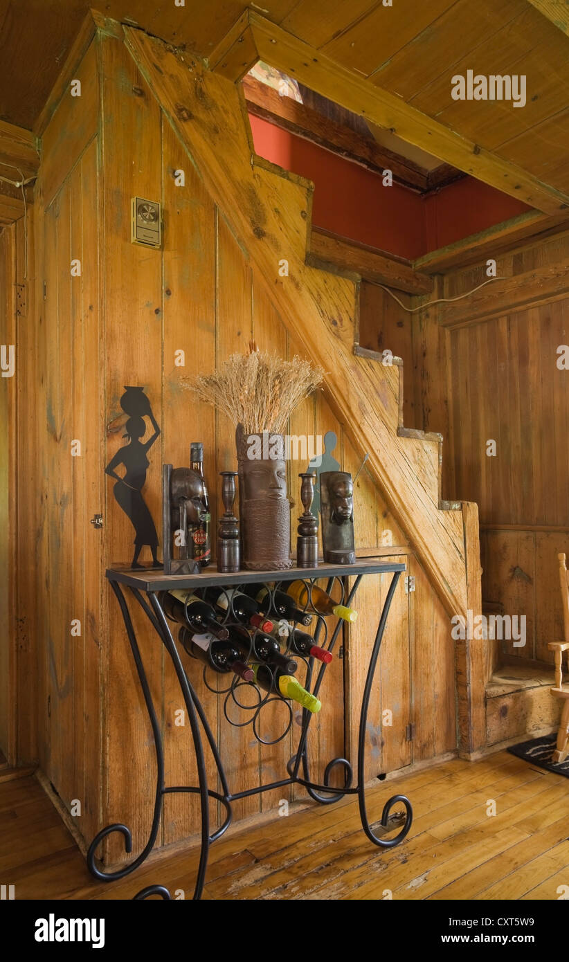 Support de vin en face d'un ancien escalier en bois dans une ancienne résidence de style cottage Canadiana log home, vers 1840, au Québec, Banque D'Images